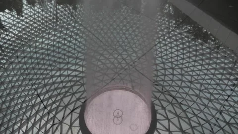 Pan up from reflection of HSBC water vortex fountainat Jewel Video stock 294343433