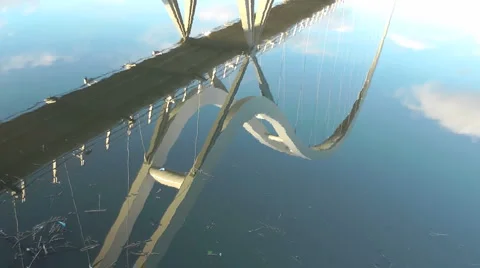 Pan up from reflection in river to Infinity Bridge Stock Footage 1058554