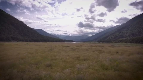Pan up revealing wide landscape with mountains - Drone Stock Footage