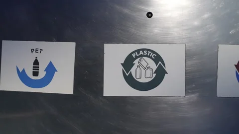 Pan right across PET plastic and metal labels on a waste sorting bin 库存影片 346814744