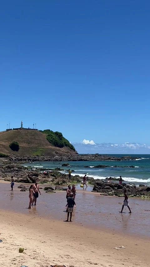 Pan right along busy Farol da Barra beach in Salvador Brazil Vidéo 343581276