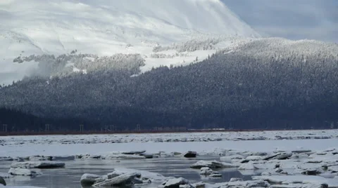 Pan Right Broken Ice River, Distant Snowy Mountain Range 2 Stock Footage 38053774