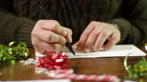 Pan Right From Candy Canes to Man Writing in Christmas Card Stock Footage 56641758