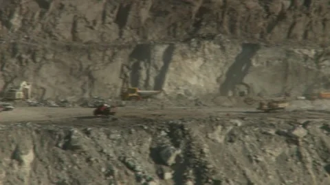 Pan right of construction vehicles working on an opencast mine Stock Footage 312400337
