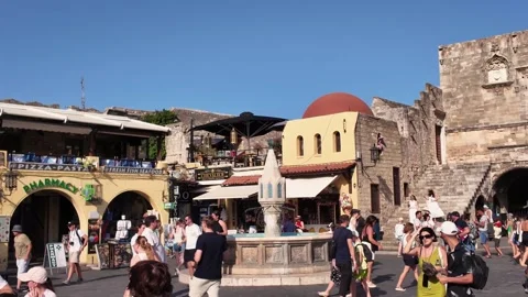 Pan right of crowded Hippocrates Square and Castellania building in Rhodes Vidéo 340575917