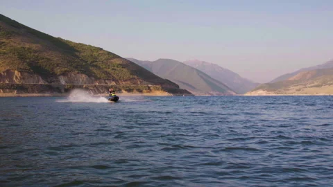 Pan right Full front to back shot of two guys riding one wave runner going r Stock-Footage 167803430