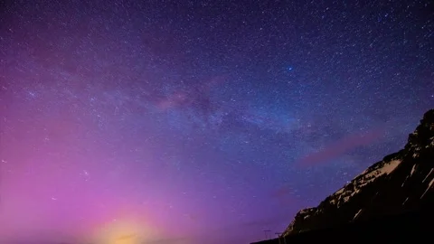 Pan right on large steep snowy mountain with gorgeous starlit sky Stock Footage 160809337