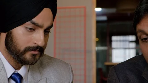 Pan right to left on close up faces of a curly woman, senior man and a Sikh man  Stock Footage 102560789