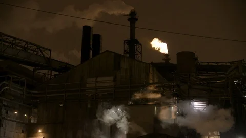 Pan right to left of factory, smoke and gas stacks at night Stock Footage 89945445