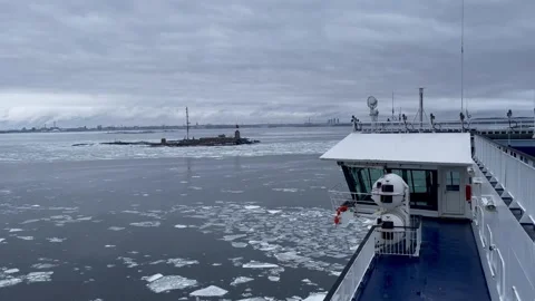 Pan from right to left of a ship sailing past a lighthouse in icy waters Stock Footage 281849867