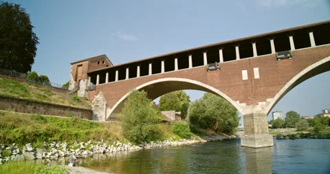 Pan Right of Length of Covered Bridge from River Sandbar in Pavia, Italy Stock Footage 202623848