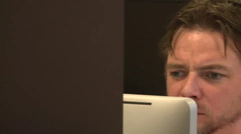 Pan Right to Office Worker Looking at Monitor through Shelves Stock Footage 58241340