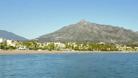 Pan-right over Banús Beach toward majestic La Concha mountain, Marbella, Costa Vídeo Stock 328511486