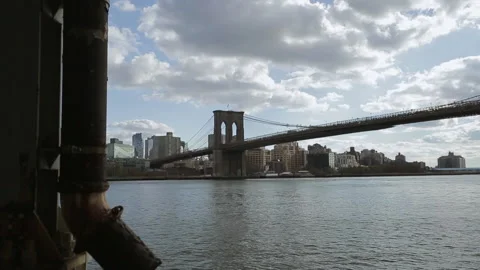 Pan-right of pipe or post on pier looking toward Brooklyn Bridge, New York, USA Stock Footage 202903942