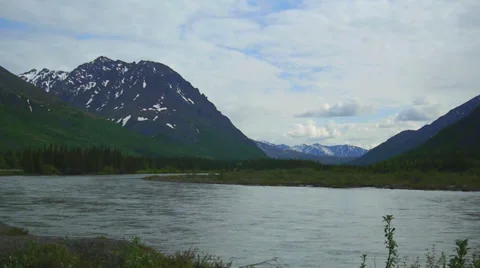 Pan Right River Flows Through Grassy Mountain Valley 2 Stock Footage 37433774