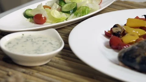Pan right on roasted sea bream fish with with vegetables, sauce, and fresh salad Stock Footage 122233258