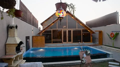 Pan right shot of house facade with pool and decoration in leisure area Stock Footage 168339786