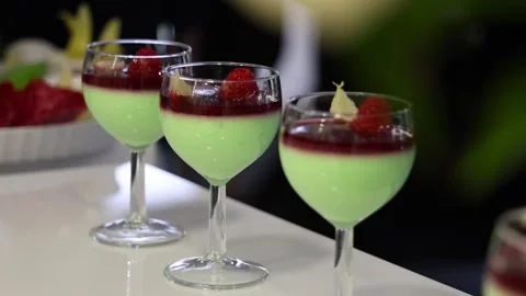 Pan Right Slow Motion Shot of Mint Dessert Glasses with Raspberries on Table Stock Footage 327482354