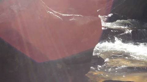 Pan to right water cascade flowing over rock in a river 動画素材 103422409