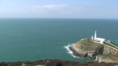 Pan right on white lighthouse by the Irish Sea in Anglesey Stock Footage 33846252