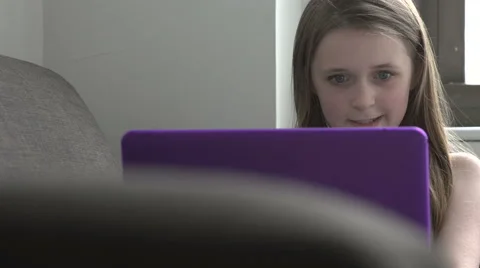 A pan right to a young girl using a laptop Stock Footage 44116997