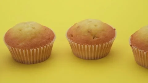 Pan on row of muffins on yellow background Stock Footage 154126690