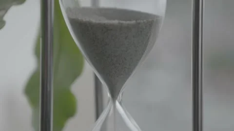 Pan of Sand Falling through Hourglass Stock Footage 159875142