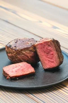 Pan seared fillet mignon medium rare on a plate. Stock Photos