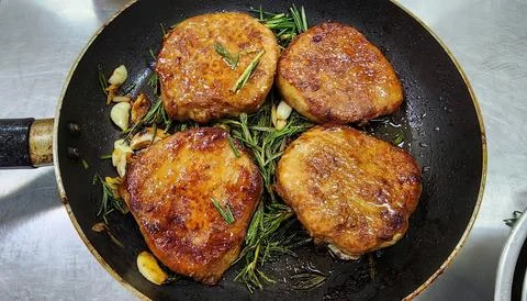Pan-Seared Pork Chops with Fresh Rosemary and Garlic in a Skillet Stock-Fotos