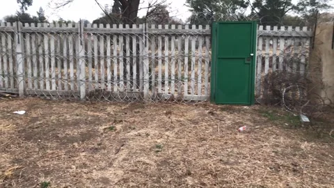 Pan of a security wall with barbed wire. Hand held. Video stock 252348092