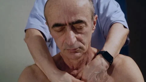 Pan Up of Senior Relaxed Face During Neck Massage by Professional Masseur Stock-Footage 311382610