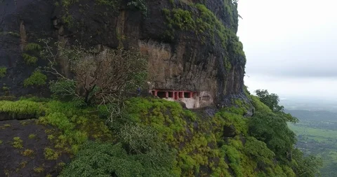 Pan shoot of trail on mountain face leading to ancient cave Stock Footage 117089577