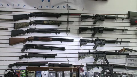 Pan Shot of Automatic Guns and Weapons on Pawnshop Wall Stock Footage 199731546