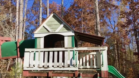 Pan shot of children’s swing set by trees during autumn/fall Stock Footage 83020525