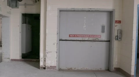 A pan shot of a closed freight elevator in an abandoned factory. Video stock 65504597