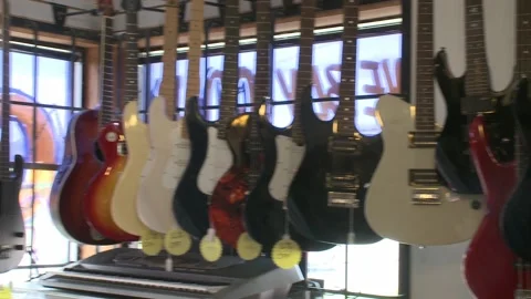 Pan Shot of Electric Guitars Hanging in Minnesota Pawn Shop Stock Footage 198546989