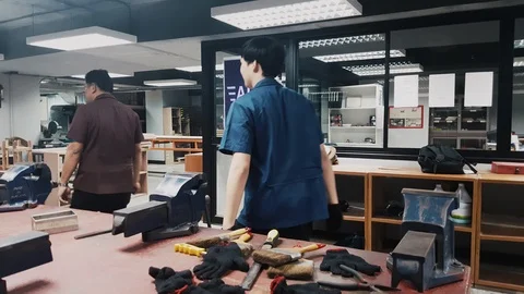 Pan shot of Engineering Student hand file a hole in a piece of metal Stock-Footage 102570771