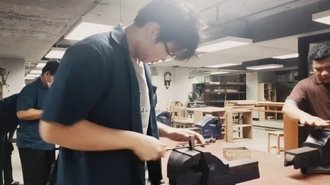  Pan shot of Engineering workshop class with student hand file metal Stock-Footage 102571632