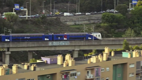Pan Shot Fertagus Blue train passing by the city on a Lisbon bridge Video stock 232271153