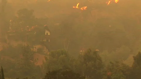 Pan-up shot of fires raging near a Southern California community Stock Footage