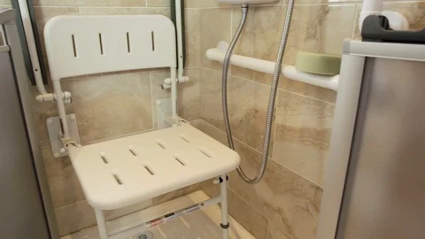 Pan shot of foldable disabled seat inside shower area with foldable doors 動画素材 129794456