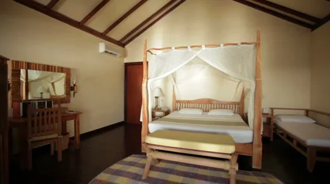 Pan shot four-poster bed in bungalow Stock Footage 1018627