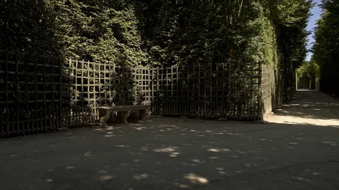 Pan shot in gardens of Versailles with an empty bench and alley 스톡 동영상 117374340