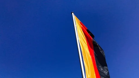 Pan shot of German flag before blue sky Stock Footage 95755531