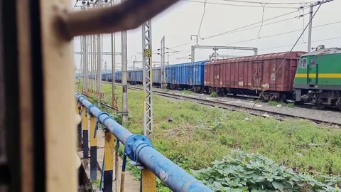 Pan shot of a goods train and a passenger train halted side by side on para.. 스톡 동영상 313381375