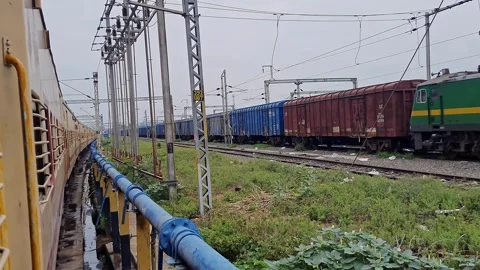 Pan shot of a goods train and a passenger train halted side by side on para.. Stock Footage 313381454