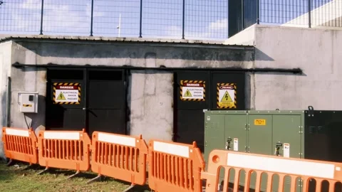 A pan shot of a high voltage electricity substation and backup generator Stock Footage 165032855