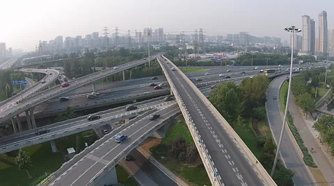 Pan shot of a huge construction site and vehicles driving through a bridge Stock Footage 42404681