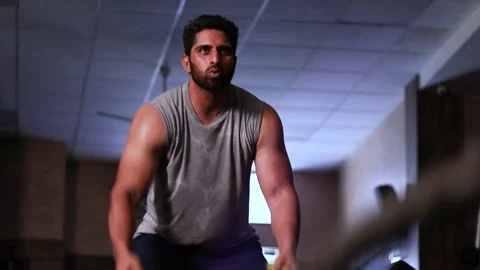 Pan shot of Indian Man doing exercise with Battle Rope in low Light Stock Footage 135629736