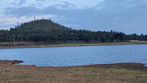 A pan shot of a large drought-stricken rural lake with stagnant water by an.. Stock-Footage 346816948